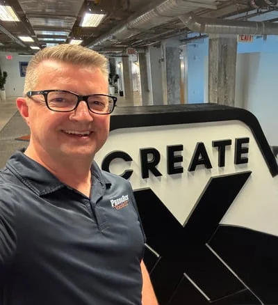 Greg Gibbs smiling in front of the CREATE-X sign at Georgia Tech